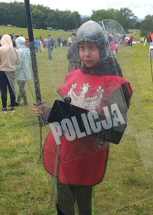 dziecko przebrane za rycerza z tarczą z napisem Policja