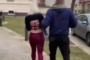 Zatrzymana kobieta prowadzona przez policjanta